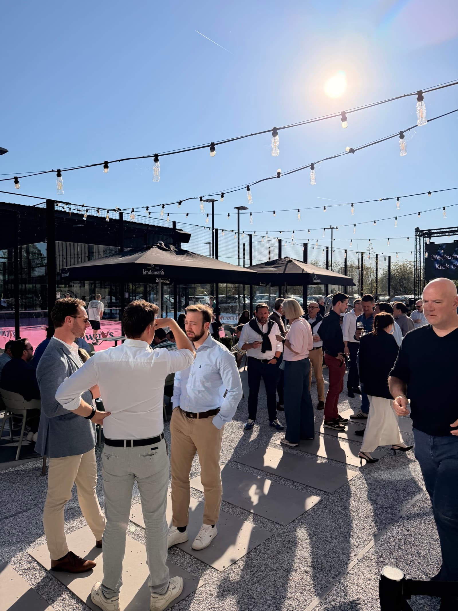 Collega's netwerken op het terras naast de padelterreinen van Belleheide