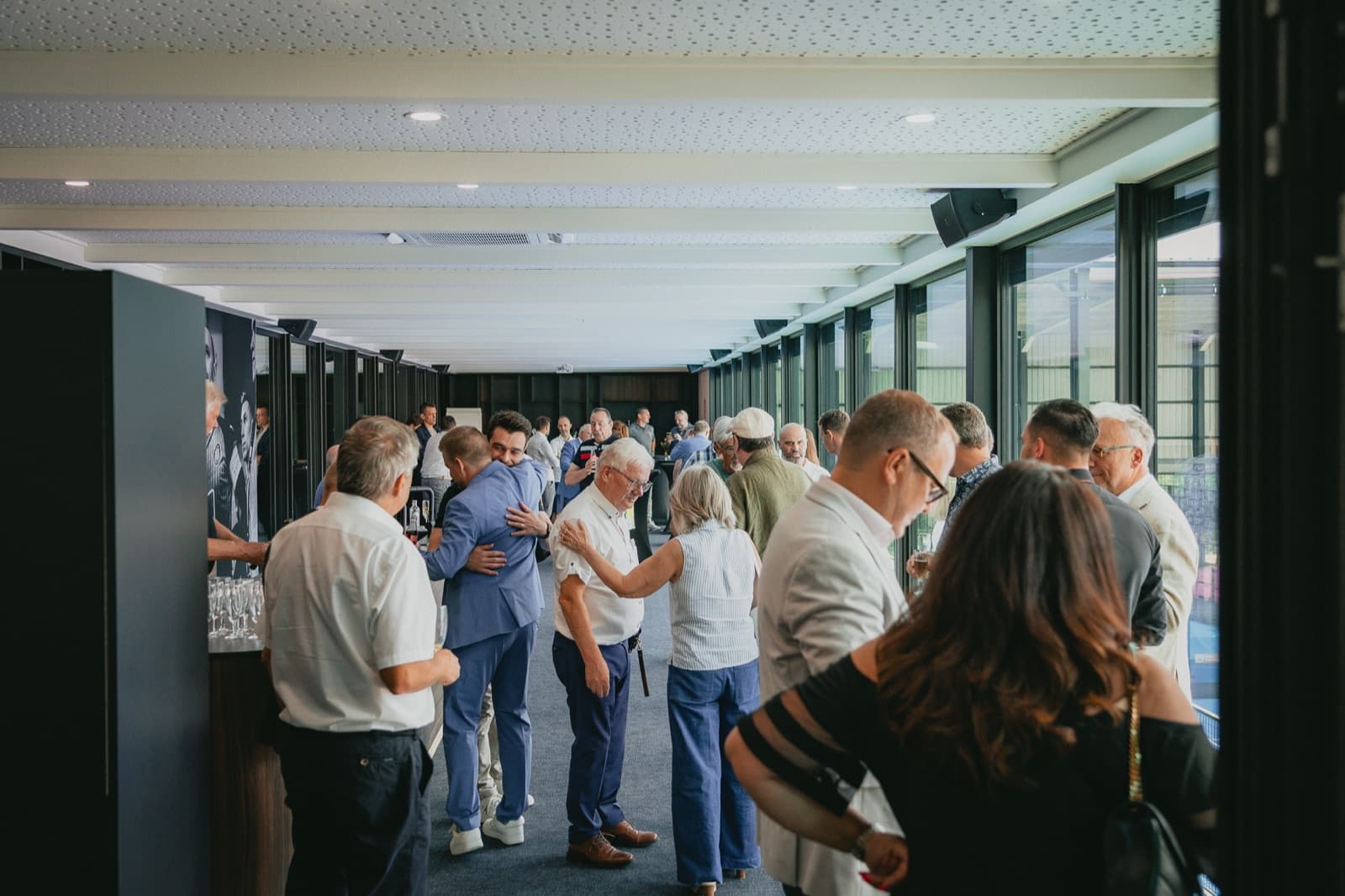 Gasten in de Skybox-lounge van Belleheide met zicht op de terreinen